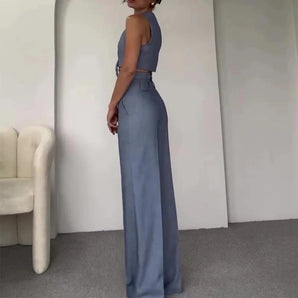Light blue sleeveless high-waist backless formal jumpsuit displayed on a mannequin, showcasing its elegant design with a fitted waist and flowing pant legs.