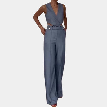 
A light blue sleeveless high-waist formal jumpsuit with a backless design, showing a close-up of the shoulder and neckline.