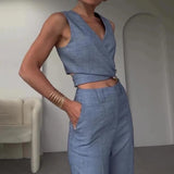 
A light blue sleeveless high-waist formal jumpsuit featuring a backless design, displayed on a mannequin. The jumpsuit has a fitted waist, wide legs, and a sophisticated appearance suitable for formal occasions.