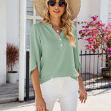 Light blue V-neck split sleeve button-front blouse for women. Elegant top with a stylish design, showcasing shoulder details and fashionable appearance.