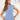 Woman wearing a light blue V-neck twist-front blouse with short sleeves, size large (40/42).