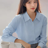 Light blue women's blouse with a minimalist design, featuring a collar and long sleeves, suitable for casual and office wear.