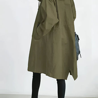 Olive green women's oversized double-breasted trench coat in size 3XL displayed on a mannequin. The coat features a classic collar, long sleeves, and falls to the knee, showcasing a chic and timeless fashion design ideal for layering.
