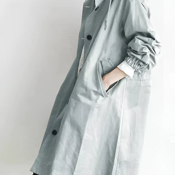 Light gray women's oversized double-breasted trench coat with long sleeves, wide lapels, and a belted waist.