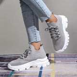 Light grey women's fashion sneakers featuring breathable mesh and a cushioned sole, displayed against a neutral background.