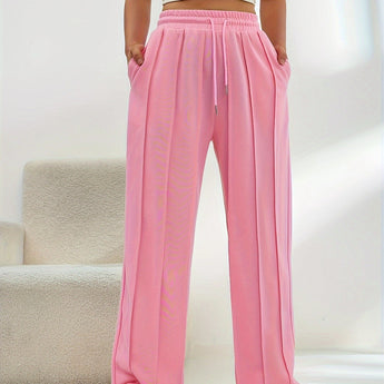 Women's light pink high-waist joggers featuring a stylish and comfortable design, highlighting elements like the waistband and knee area, with a focus on a soft, peachy pink color.