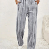 Light pink high-waist joggers showcasing a comfortable fit, styled for women in a fashionable design. Model wearing gray variant, size XXL, highlighting the waist and thigh areas, paired with a blazer.