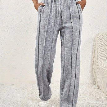 Light pink high-waist joggers showcasing a comfortable fit, styled for women in a fashionable design. Model wearing gray variant, size XXL, highlighting the waist and thigh areas, paired with a blazer.