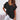 Woman wearing a light pink V-neck blouse with short sleeves and a relaxed fit, suitable for casual summer outings.