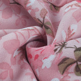 Light pink floral blouse with a V-neck design, featuring a delicate flower print and long sleeves.