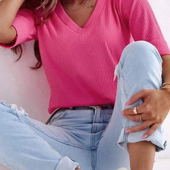 Light pink V-neck ribbed sweater for women, paired with jeans; showcases shoulder, neck, and sleeve details in casual spring fashion.