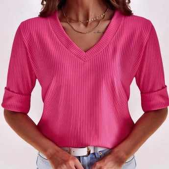 Light pink V-neck ribbed sweater with long sleeves, worn by a woman, showcasing casual spring fashion.