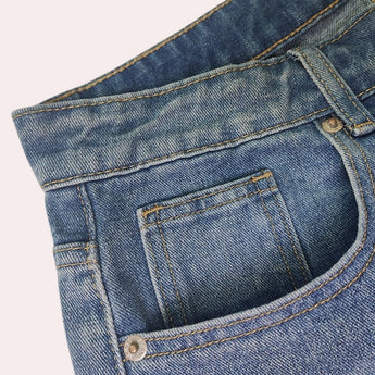 Light-wash high-waist denim jeans in faded blue with a five-pocket design, featuring a button closure, visible stitching, and a classic denim texture.