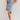 Light wash sleeveless denim midi dress in blue, showcasing a fitted silhouette with a zipper back. The model wears size XL, highlighting the dress's knee-length design and waistline accentuation.