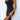 
A light wash sleeveless denim midi dress with a fitted design, zipper back closure, and casual style. The dress is modeled by a person showcasing its shoulder and neck details, with emphasis on the waist and leg structure.