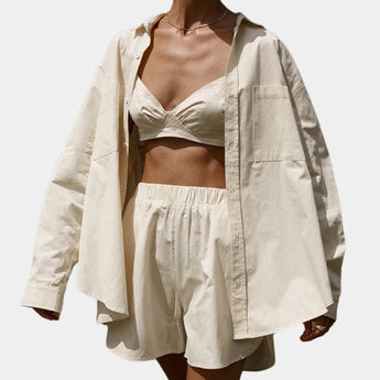 Light yellow women's oversized silk shirt with a luxury soft touch, featuring a collar and long sleeves, styled in the apricot color variant. The shirt has a comfortable fit with emphasis on the waist, creating an elegant and fashionable look.