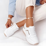 Beige low-top women's fashion sneakers on a model's feet, showcasing a chic and breathable design.