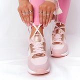 A pair of lightweight beige women's low-top fashion sneakers being worn, showcasing their chic and breathable design.