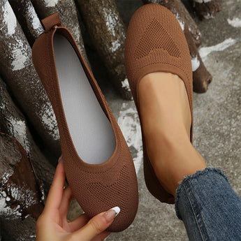 A pair of lightweight pink ballet flats made from breathable mesh material, perfect for summer walking, being worn by someone in jeans.