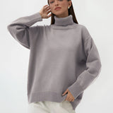 A person wearing a lime green chunky knit turtleneck sweater, demonstrating cozy winter fashion, with sleeves covering the arms and a relaxed fit around the waist. The sweater complements a light brown color scheme suitable for a large size. The person appears happy and comfortable, showcasing the sweater's stylish design.