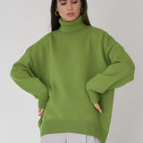 Olive green chunky knit turtleneck sweater with long sleeves and a cozy fit, worn by a model showcasing the sweater's wide collar and textured knit design.