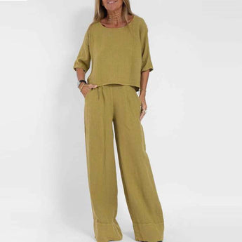 A woman wearing a green linen jumpsuit in a casual wide-leg high waist style, suitable for summer. The outfit features a collar and short sleeves, perfect for a relaxed yet chic look.