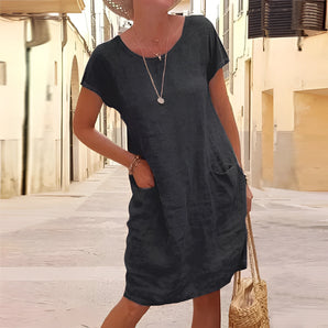 Grey linen knee-length tunic dress featuring short sleeves, a round collar, and a relaxed fit, ideal for casual summer outings and travel.