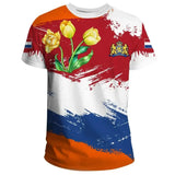 Orange T-shirt featuring a heraldic lion with crossed swords graphic on the front, short sleeves, and a round collar, displayed against a backdrop with a few plants.