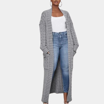 Long black ribbed oversized knit cardigan in gray, worn by a woman over a T-shirt and jeans, featuring long sleeves and open front style, suitable for winter wear.