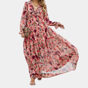 Long bohemian-style floral maxi dress made of chiffon with a V-neckline, featuring long sleeves and a fitted waist for a flattering silhouette.