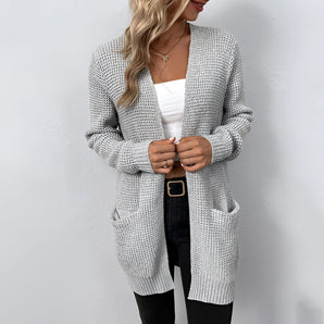Long gray chunky knit open front cardigan with pockets, featuring long sleeves and an oversized fit, shown on a model with a dress shirt, highlighting the cardigan's texture and design details.