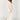 Long sleeve white crochet midi dress worn as a bohemian beach cover-up, featuring intricate crochet patterns, a relaxed fit, and knee-length design.