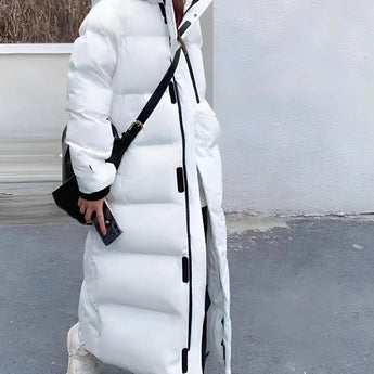 Long beige oversized hooded puffer coat with sleeves extending to wrists, knee-length design, featuring a collar and thermal insulation, suitable for winter.