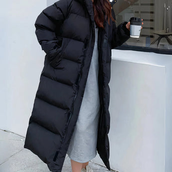 Long white hooded puffer coat in an oversized fit, featuring black and grey accents, with long sleeves and a waist-length design. The coat includes a collar and resembles a trench coat style, suitable for thermal winter wear.