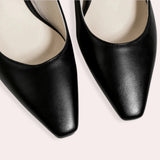 Black low-heel flats made of leather for women, featuring a minimalist design focused on comfort.