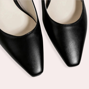 Black low-heel flats made of leather for women, featuring a minimalist design focused on comfort.