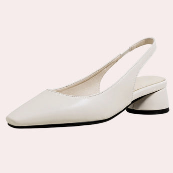Beige low-heel flats for women with a minimalist design, crafted from leather for comfort, shown being worn on a human leg.