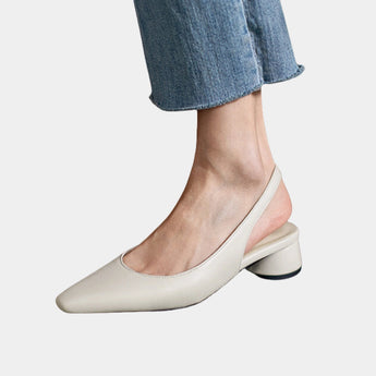 Women's low-heel black flats made of leather, worn with jeans, showing a comfortable fit suitable for a minimalist style.