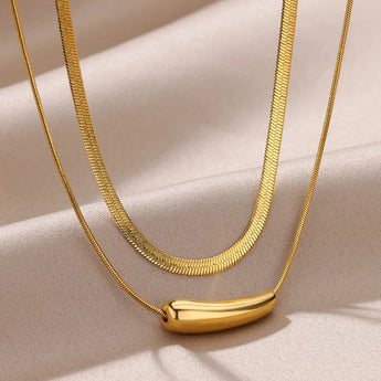 Luxurious double layer gold necklace, minimalist and versatile choker around neck, featuring natural material and elegant yellow hue.