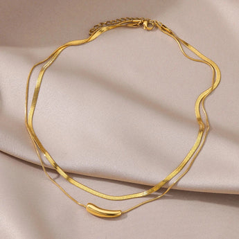 Luxurious double layer gold necklace featuring minimalist design, shown as a versatile choker made of metal, highlighting its natural material and fashionable appeal.