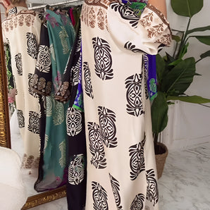 Luxurious floral kimono robe with a high-end designer style, featuring a white base adorned with green floral patterns. The robe highlights elements such as a collar, long sleeves, and a cinched waist, ideal for elegant loungewear.