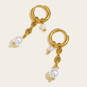 Luxurious gold floral hoop earrings with baroque pearl drops, featuring intricate metalwork and elegant design.