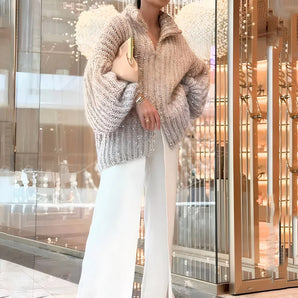 Luxurious metallic chunky knit sweater with oversized collar, featuring a ribbed pattern and long sleeves, styled in a fashion-forward manner.