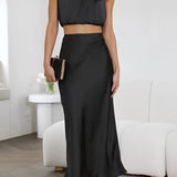 Luxurious silk satin skirt set featuring a high-waist maxi skirt and a backless halter top in Nero color, size XL. The set is elegantly designed with a focus on the waist and neck, offering a sleek and sophisticated look.