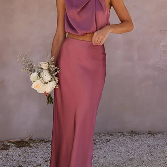 Luxurious pink silk satin skirt set featuring a high-waist maxi skirt paired with a backless halter top, designed in an XL size. The set highlights elegant fashion design, emphasizing the waist and showcasing shoulders and neckline.