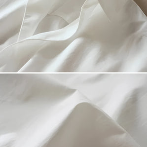Luxurious white satin fabric with a high-quality glossy finish, ideal for bedding, displayed with a smooth texture and subtle sheen.