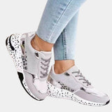 Luxurious women's designer sneakers with an animal print and metallic accents, showcased in a stylish fashion setting featuring denim and sportswear elements.