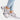 Luxurious women's designer sneakers with an animal print and metallic accents, showcased in a stylish fashion setting featuring denim and sportswear elements.
