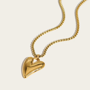Luxury 18K gold heart pendant necklace from Ya-Chan, featuring a sculptural design on a delicate chain.