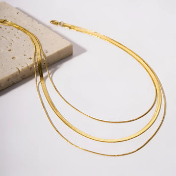 Elegant 18K gold-plated snake chain necklace with sleek design, showcasing luxurious and waterproof body jewelry accessory.